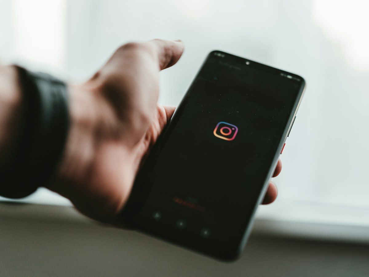 Hand hält Smartphone mit geöffneter Social-Media-App