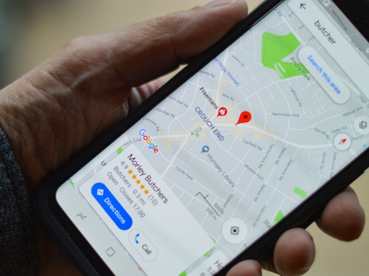 Smartphone mit geöffneter Kartenansicht in der Hand