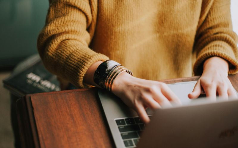 Person schreibt Texte am Laptop